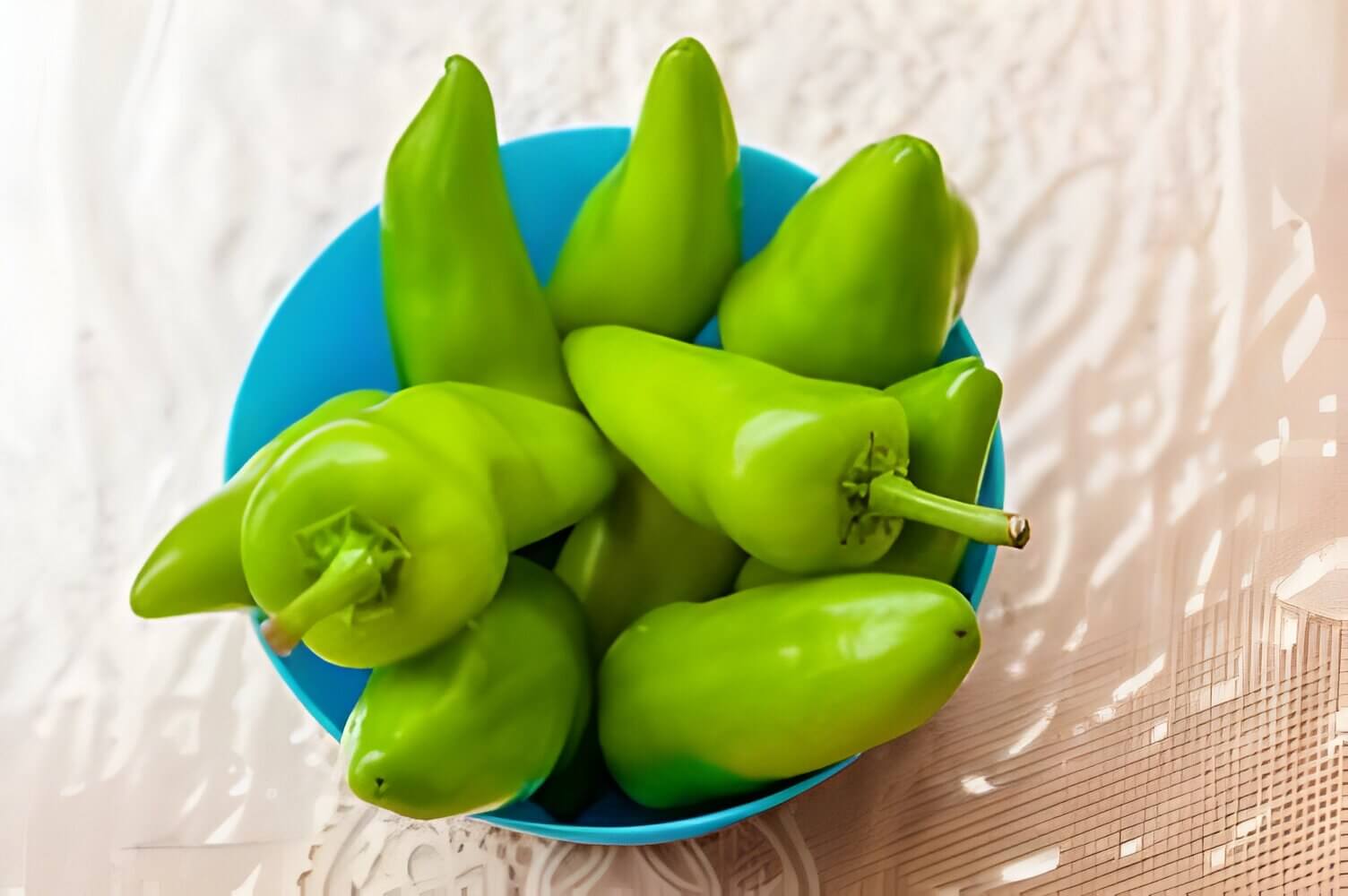 Green banana peppers in a blue bowl.